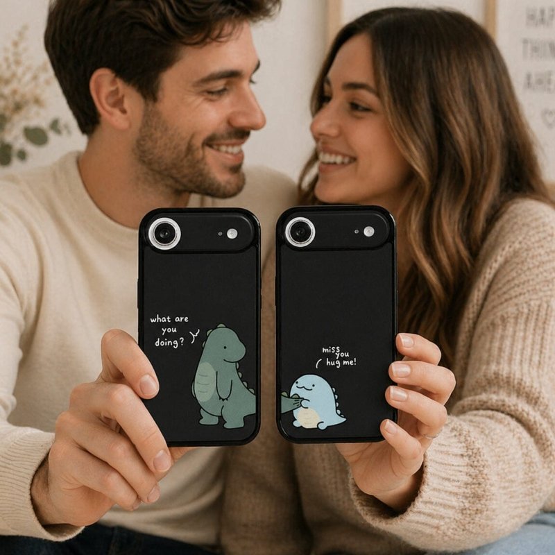 Man and woman holding black phone cases with cartoon designs